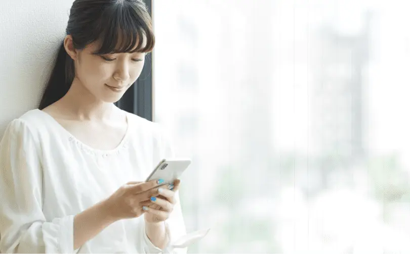 女性がスマホで定期検診の結果を確認している